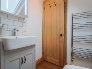 a bathroom with a sink and a wooden door at Rose Cottage in West Buckland +23 photos
