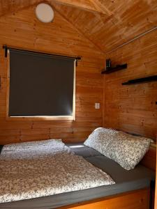 a bedroom with a large screen in a wooden wall at Tiny House na pevnosti Křelov in Olomouc