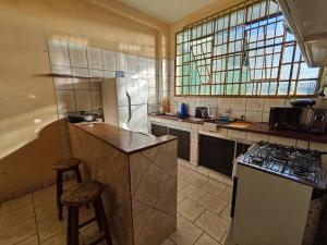 a kitchen with a refrigerator and a counter and a stove at Sereny Stone Palace in Rondonópolis