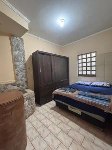 a bedroom with a large bed and a stone wall at Sereny Stone Palace in Rondonópolis