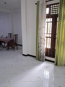 a dining room with a table and a window at Home mr in Matara +11 photos