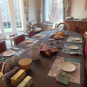 a dining room table with plates and food on it at ImaginaSoi in Dunières