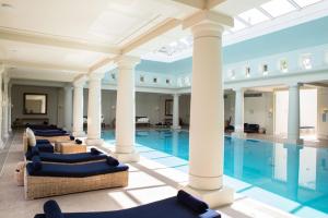a pool with chairs and columns in a building at Anassa in Polis Chrysochous
