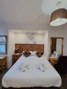 a bedroom with a large white bed with two pillows at Riverside Hotel in Norwich