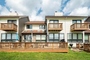 a large house with a wooden deck on a lawn at Ski Harbor 14 in McHenry