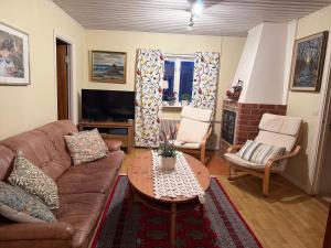un soggiorno con un divano e un tavolo di Almagården lantlig miljö a Svängsta