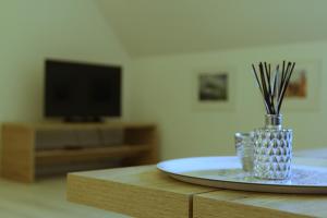 a table with a plate and a vase with grass at Ferienwohnung 1 ANNA IFF in Würzburg
