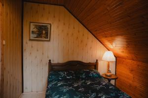 a bedroom with a bed in a wooden wall at Apartament w Zabytkowej Stajni nad Jeziorem z Dostępem do Parku i Sąsiedztwem XIX wiecznego Dworku Modrzewiowego in Szteklin
