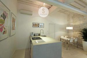 a kitchen with a sink and a table in a room at Côté Pur Arles Centre in Arles