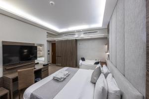 a hotel room with a bed and a flat screen tv at Heaven Prestige Hotel in Jounieh