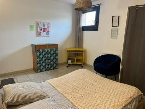 a bedroom with a bed and a desk and a chair at Vazaha grand et bel appartement classé 3 étoiles in Lavelanet