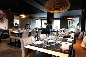 a dining room with tables and chairs and lights at Durbuy Ô Restaurant Hotel in Durbuy