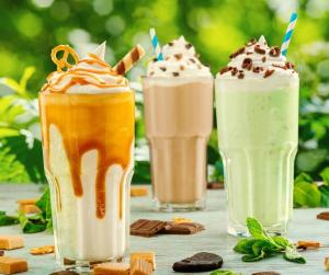 three milkshakes sitting on top of a table at Lulu s dream cafe in Welata