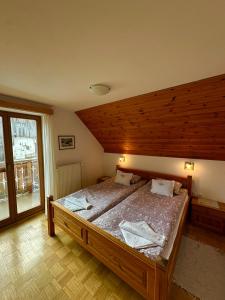 a bedroom with a large bed with a wooden ceiling at Kmetija Matk in Solčava