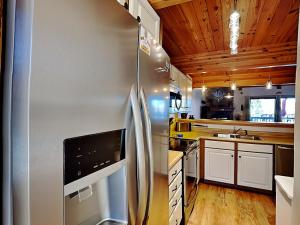 a kitchen with a stainless steel refrigerator and wooden ceilings at Sunplace 02 in McHenry