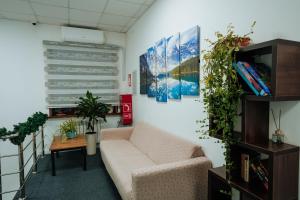 a living room with a couch and some plants at Азия Hostel in Shymkent