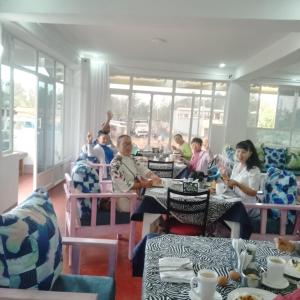 a group of people sitting at tables in a restaurant at W hotel Kimana in Kimana
