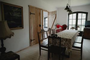 a bedroom with a bed and a table and chairs at Apartament w Zabytkowej Stajni nad Jeziorem z Dostępem do Parku i Sąsiedztwem XIX wiecznego Dworku Modrzewiowego in Szteklin