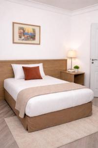 a bedroom with a large bed with a wooden headboard at Hotel Montana Paris Lafayette in Paris +19 photos