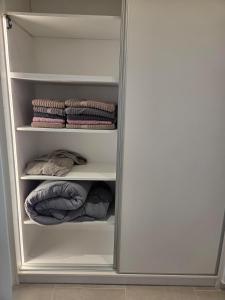 a closet with white shelves and folded towels at Karatza's suite 2 in Chios