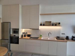 a kitchen with white cabinets and a sink at Karatza's suite 2 in Chios
