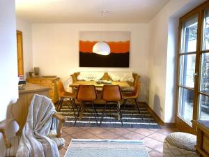 a dining room with a table and chairs at AlpenLodge Chiemsee in Nußdorf