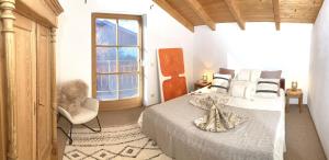 a bedroom with a bed and a chair and a window at AlpenLodge Chiemsee in Nußdorf +25 photos