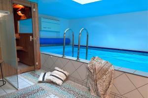 a swimming pool in a room next to a swimming pool at AlpenLodge Chiemsee in Nußdorf