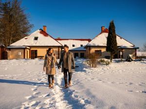 a man and a woman walking in the snow at Fotuso House in Majdany Wielkie