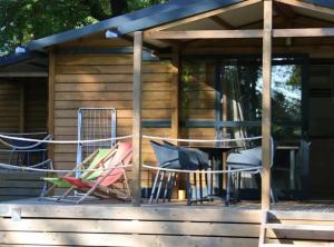 a group of chairs and a table on a deck at Chalet 3 étoiles - Piscine - ccbbgcc in Sauxillanges