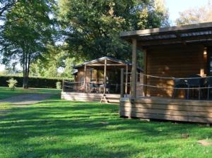 a cabin in a grassy field with a gazebo at Chalet 3 étoiles - Piscine - ccbbgcc in Sauxillanges