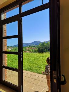 a little child looking out a door at a field at Hotel Ibaigune in Murueta