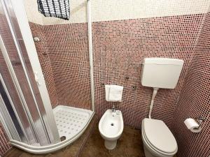 a small bathroom with a toilet and a shower at porta merlonia house minimono in Forlì