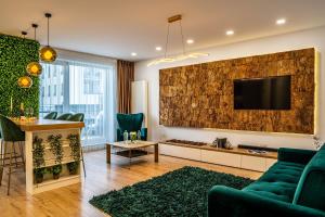 a living room with a couch and a tv on a wall at Cliché Luxury Apartment in Braşov
