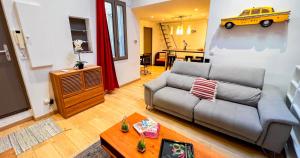 a living room with a couch and a yellow car on the wall at Duplex moderne au Palais des Papes in Avignon
