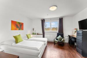 a living room with a white couch and a television at ParkVilla Puschendorf, 24-7 Self-Check-in in Puschendorf