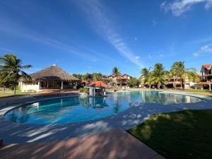 a swimming pool in a resort with palm trees at Brisas Vista Serena in Nueva Gorgona