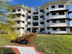 a large white building with flowers in a yard at Brisas Vista Serena in Nueva Gorgona