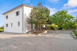 a white house with a driveway at ParkVilla Puschendorf, 24-7 Self-Check-in in Puschendorf