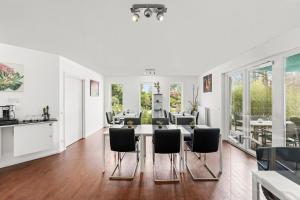 a white kitchen and dining room with a table and chairs at ParkVilla Puschendorf, 24-7 Self-Check-in in Puschendorf