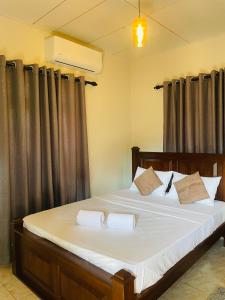 a bedroom with a large bed with black curtains at Diddi's in Weligama