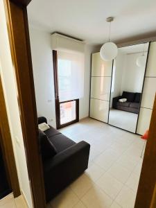 a living room with a black couch and a mirror at Appartamento Carino Splendido Trivano Panoramico IUN S3308 in Quartucciu