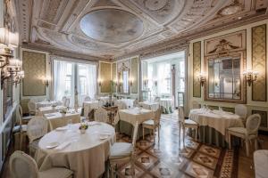 a restaurant with white tables and chairs and a ceiling at Hotel Bristol Palace in Genoa