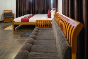 a bedroom with a bed and a couch in a room at Aroha luxury homestay in Madikeri