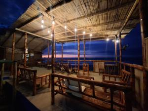 a restaurant with a view of the ocean at night at Mancora Beach House in Máncora