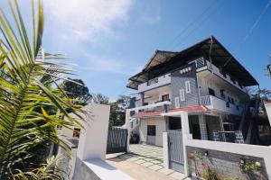 a house with a white fence in front of it at Aroha luxury homestay in Madikeri