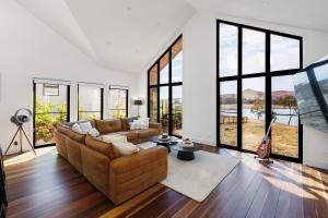 a living room with a couch and large windows at The Barn Bonnie Doon in Bonnie Doon