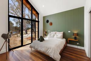a bedroom with a bed and a large window at The Barn Bonnie Doon in Bonnie Doon