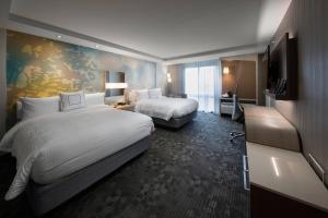 a hotel room with two beds and a television at Courtyard by Marriott Russellville in Russellville