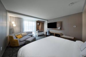 a hotel room with a bed and a couch at Courtyard by Marriott Russellville in Russellville